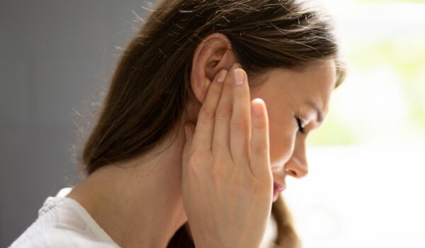 woman holding ear in pain